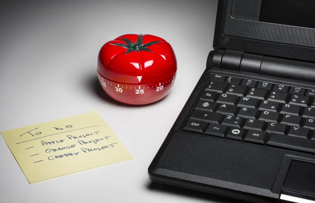 A tomato and a laptop to perform Pomodoro time management technique